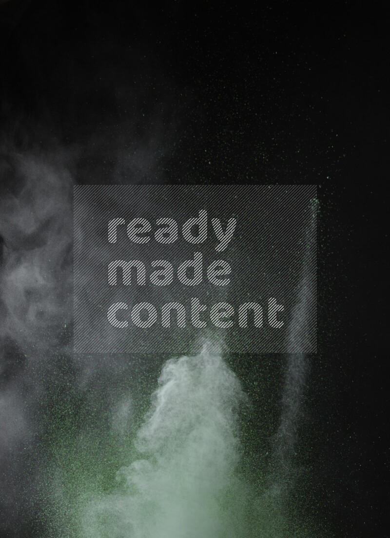 A side view of green powder explosion on black background