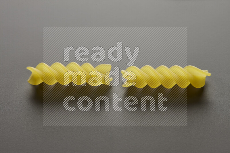 Fusilli pasta on grey background