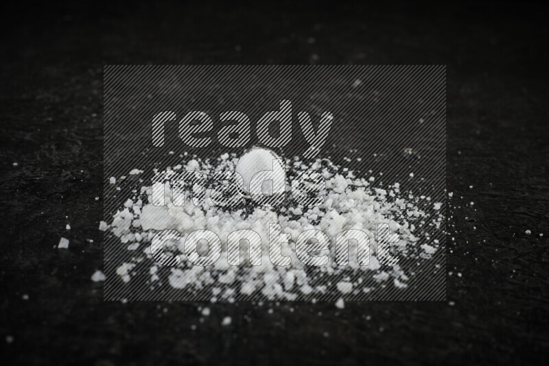 ملعقتان معدنيتان ممتلئتان بالملح الأبيض على خلفية سوداء