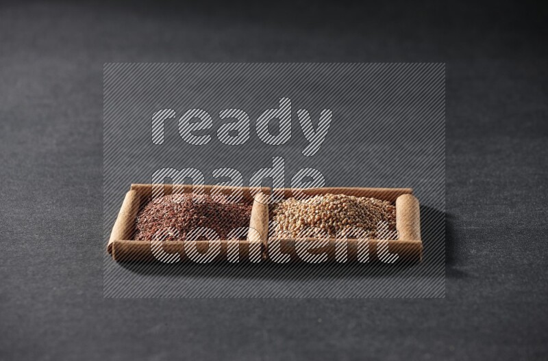 مربعان من أعواد القرفة ممتلئان بحبوب الخردل وحب الرشاد علي خلفية سوداء