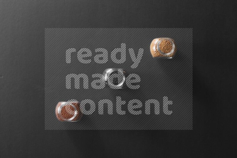 حبوب الخردل و حب الرشاد وحبة البركة في أوعية زجاجية علي خلفية سوداء