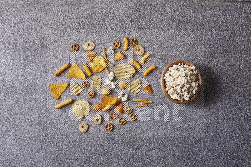 Assorted snacks in pottery bowls on grey background