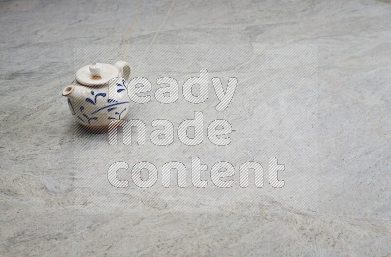 A pottery teapot on grey marble background