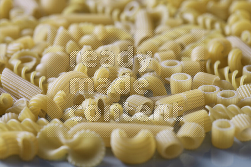 Different pasta types on light blue background