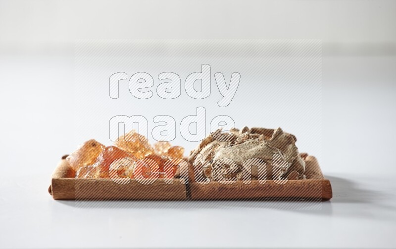 مربعان من أعواد القرفة ممتلئان بالزنجبيل المجفف والصمغ العربي علي خلفية بيضاء