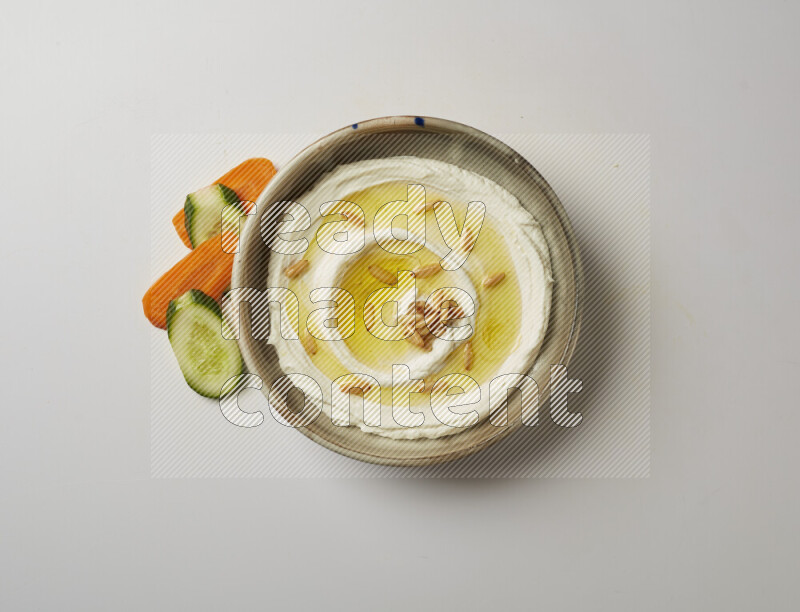 Lebnah garnished with pine nuts in a grey pottery plate on a white background