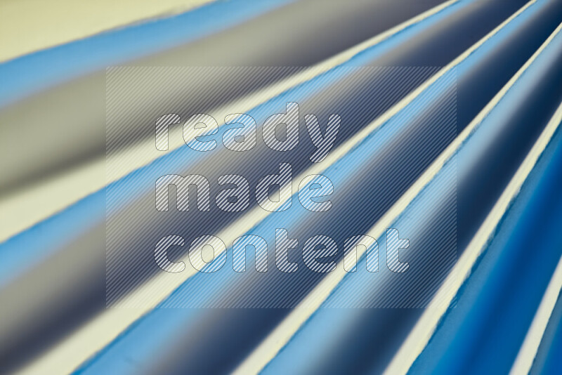 An image presenting an abstract paper pattern of lines in blue and gold tones