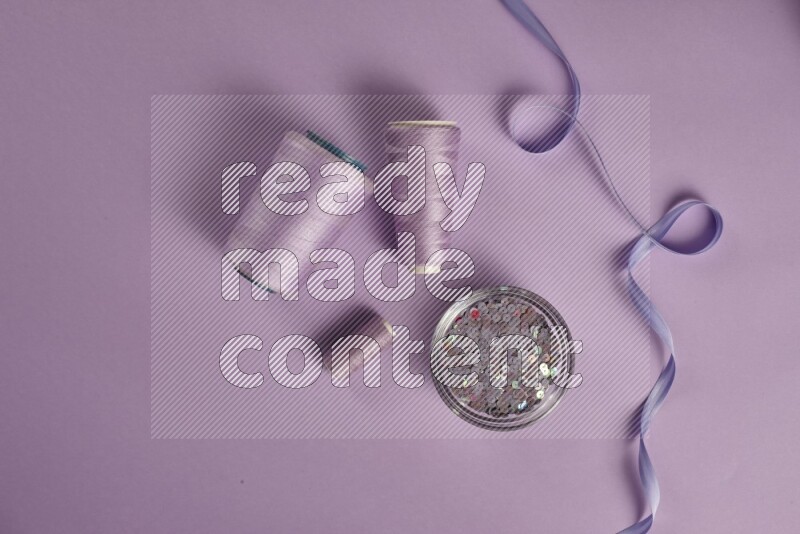 A purple collection of sewing and tailoring tools arranged on a purple background