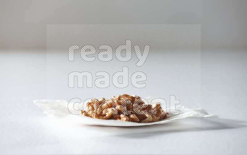 Peeled walnuts on a crumpled piece of paper on a white background in different angles