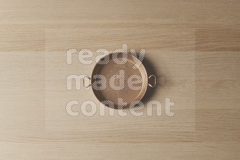 A small copper pan on light wooden background