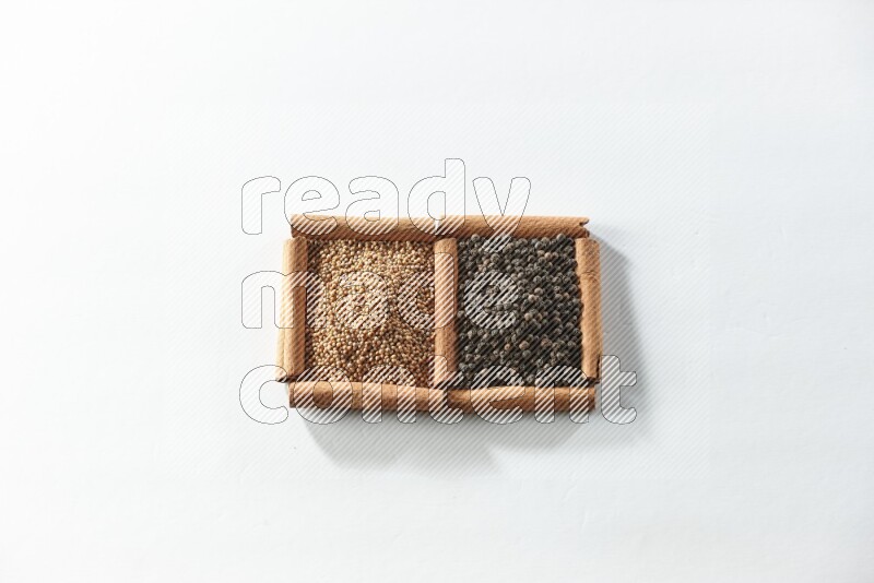 2 squares of cinnamon sticks full of mustard seeds and black peppers on white flooring