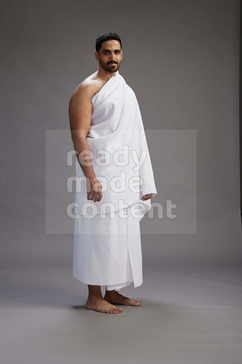 A man wearing Ehram Standing Interacting with the camera on gray background
