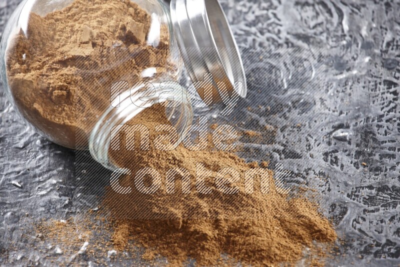 قرفة في وعاء زجاجي مقلوب علي خلفية سوداء