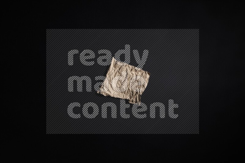 Crumpled craft paper on black background