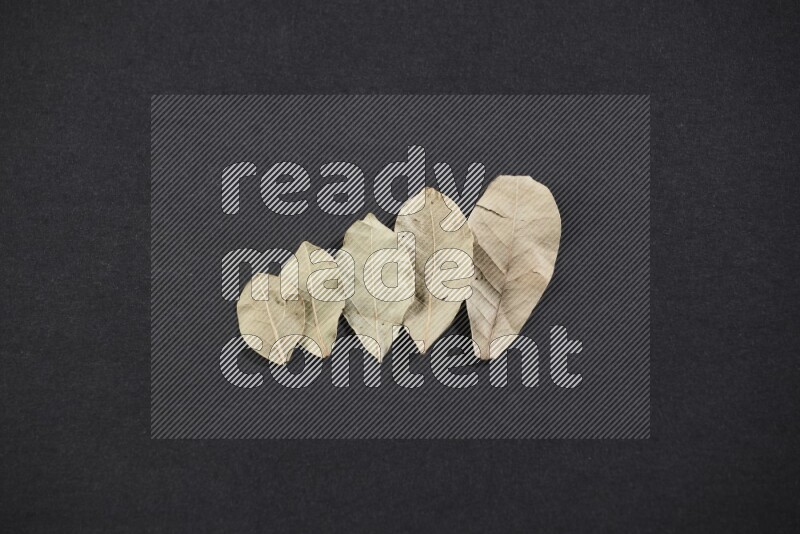 Dried bay leaves on black flooring