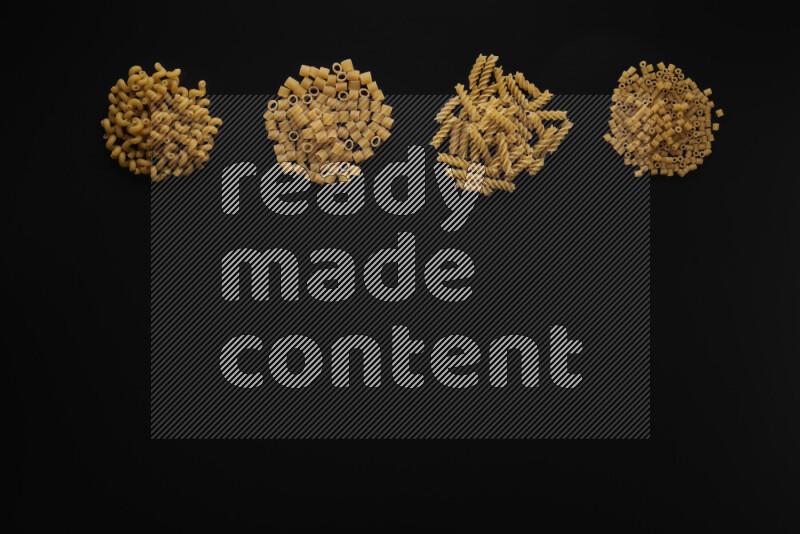 Different pasta types in 4 bunches on black background