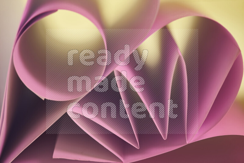 عرض فني لطيات الورق تخلق مزيج من الأشكال الهندسية، مضاءة بإضاءة ناعمة بدرجات اللون الودري والالوان الدافئة