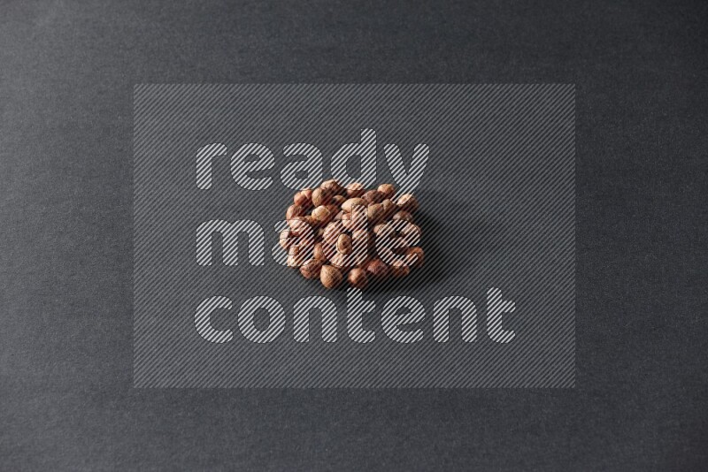 A bunch of peeled hazelnuts on a black background in different angles
