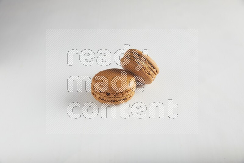 45º Shot of of two assorted Brown Irish Cream, and Brown Maple Taffy macarons  on white background