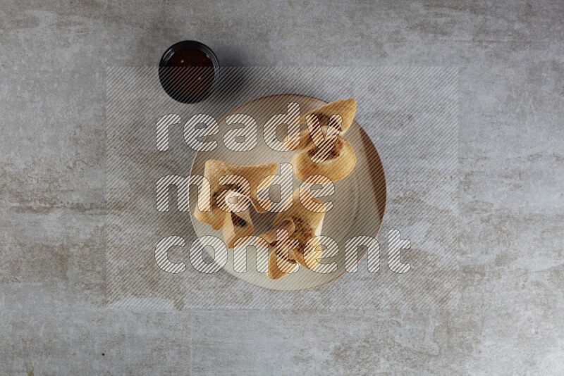 wonton cups with soy sauce ramkin on multi colored pottery on grey textured counter top