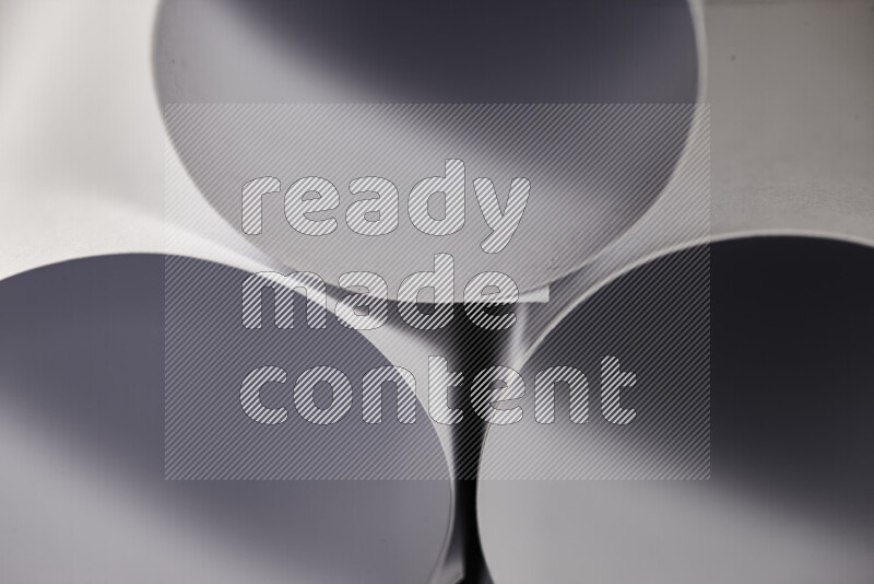 الصورة تعرض فن ورقي تجريدي بأشكال دائرية بدرجات متنوعة من اللون الرمادي