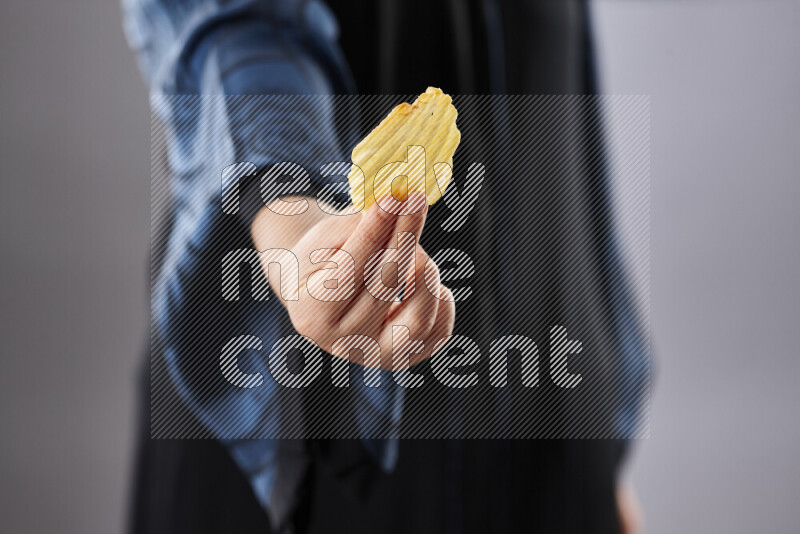 Woman in abaya holding different kinds of snacks in different positions