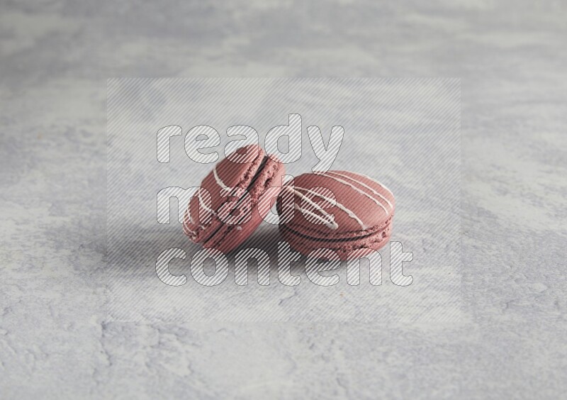 45º Shot of two Red Poppy Flower macarons on white  marble background
