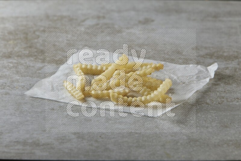 crinkle fries on parchment paper on grey textured counter top