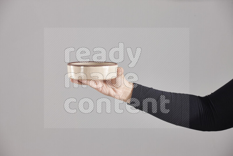 امرأة ترتدي عباءة سوداء تحمل أدوات فخارية مختلفة في أوضاع متعددة