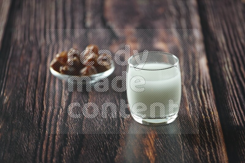Cold drinks in a glass cup with dates such as water, tamarind, qamar eldin, sobia, milk and hibiscus on wooden background