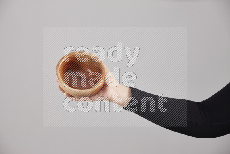 امرأة ترتدي عباءة سوداء تحمل أدوات خشبية مختلفة في أوضاع متعددة