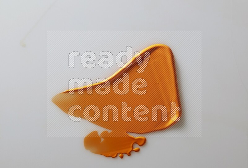 An orange single curved painting knife stroke on white background