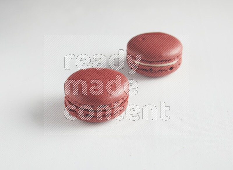 45º Shot of two Red Velvet macarons on white background