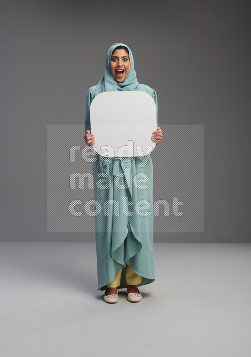 Saudi Woman wearing Abaya standing holding social media sign on Gray background