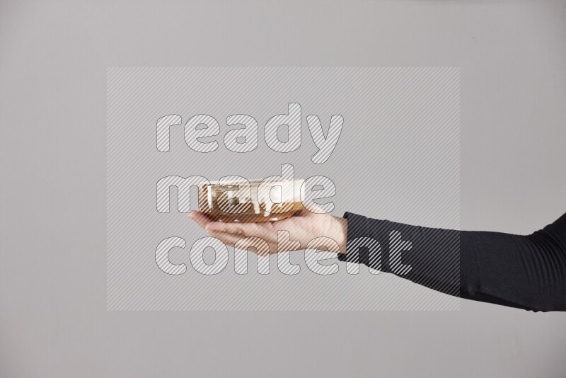 A woman in black abaya holding different pottery essentials in different positions