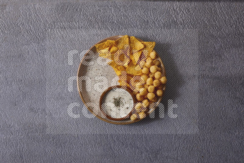 Assorted snacks in pottery bowls on grey background