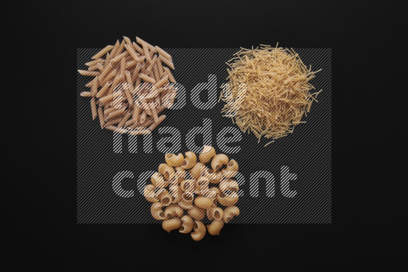 Different pasta types in bunches on black background