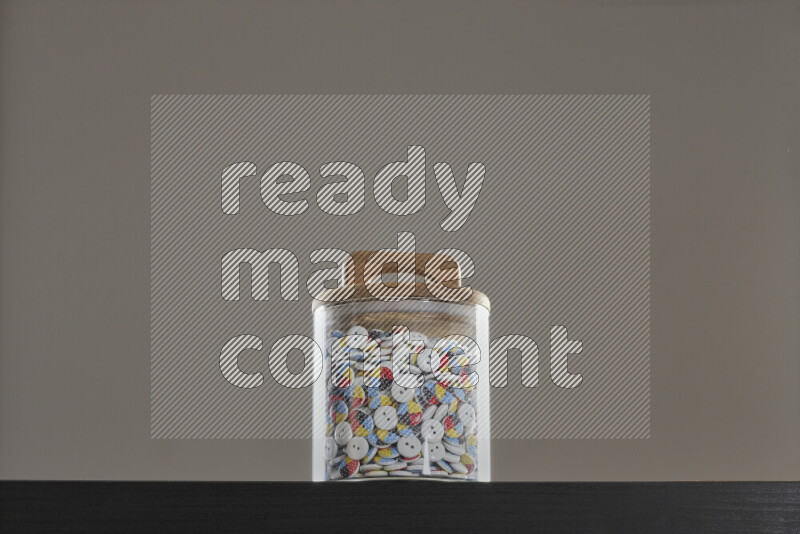 Buttons in a glass jar on black background