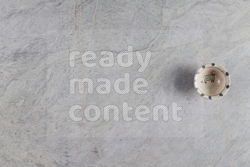 A decorative pottery plate on grey marble background