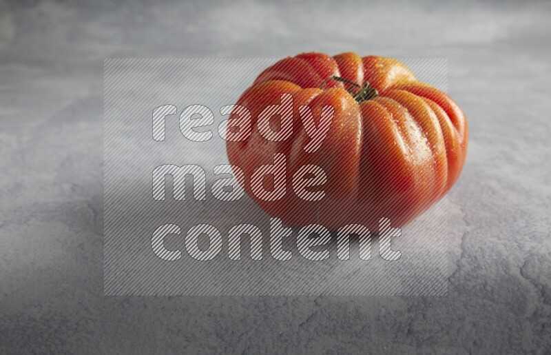 45 degree single heirloom tomato on a light blue textured background