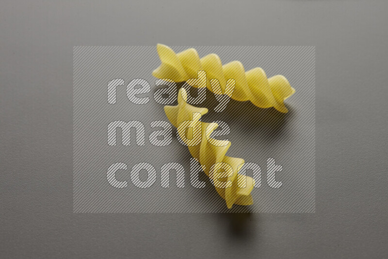 Fusilli pasta on grey background