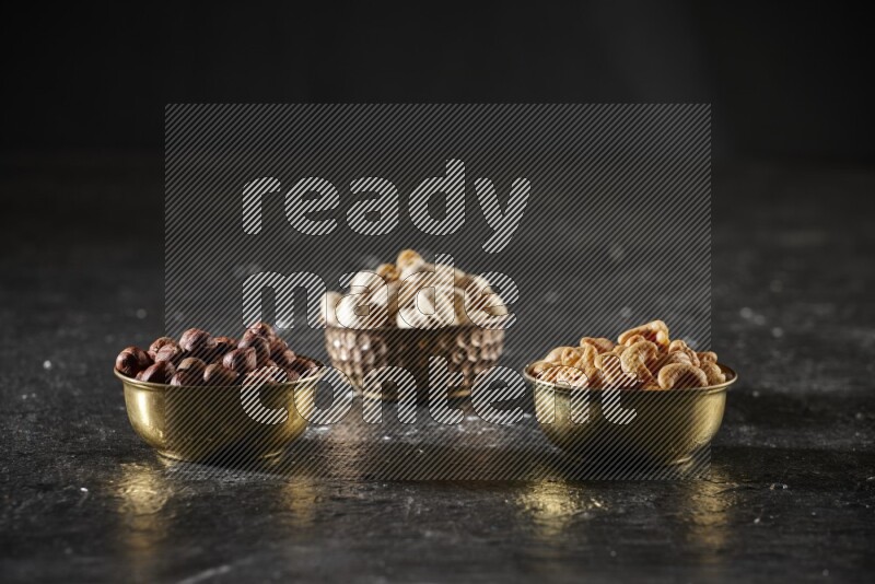 مكسرات في وعاء معدني علي خلفية سوداء