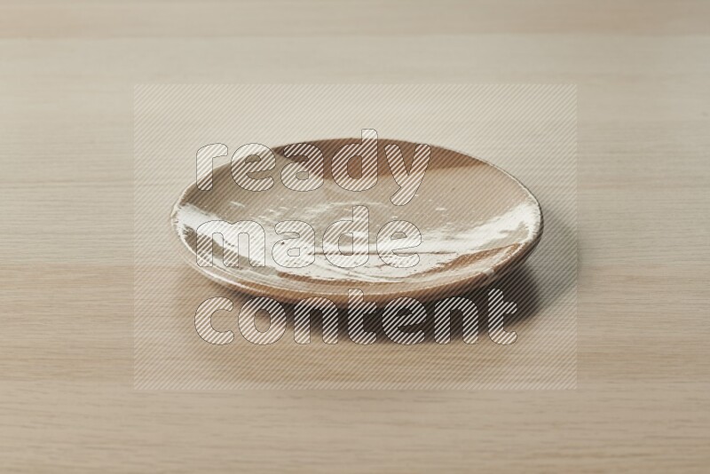 A multicolored pottery plate on light wooden background