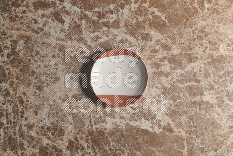 A decorative pottery plate on beige marble background