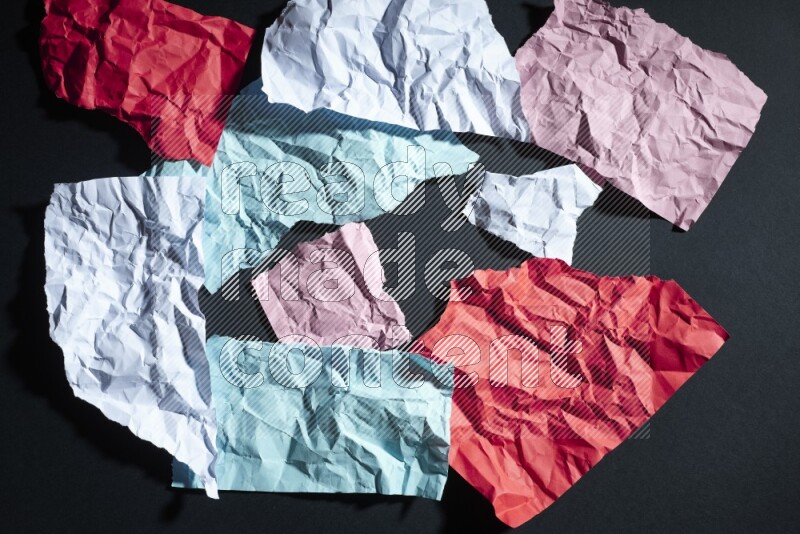Crumpled multicolored paper on black background