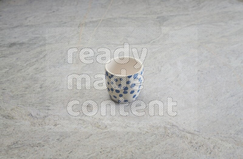 A multicolored pottery Cup on grey marble background