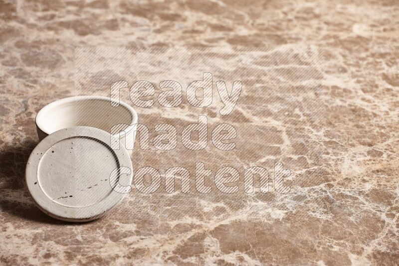 A white pottery bowl on beige marble background