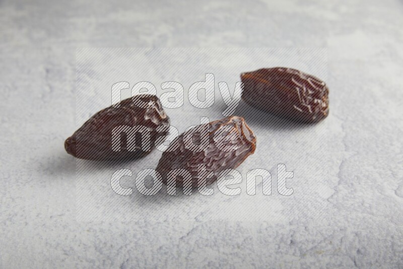 three madjoul dates on a light grey background
