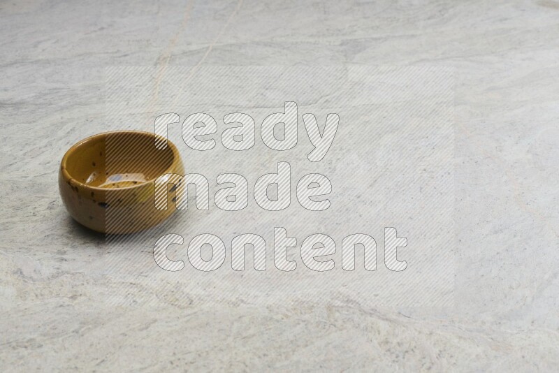 A multicolored pottery bowl on grey marble background