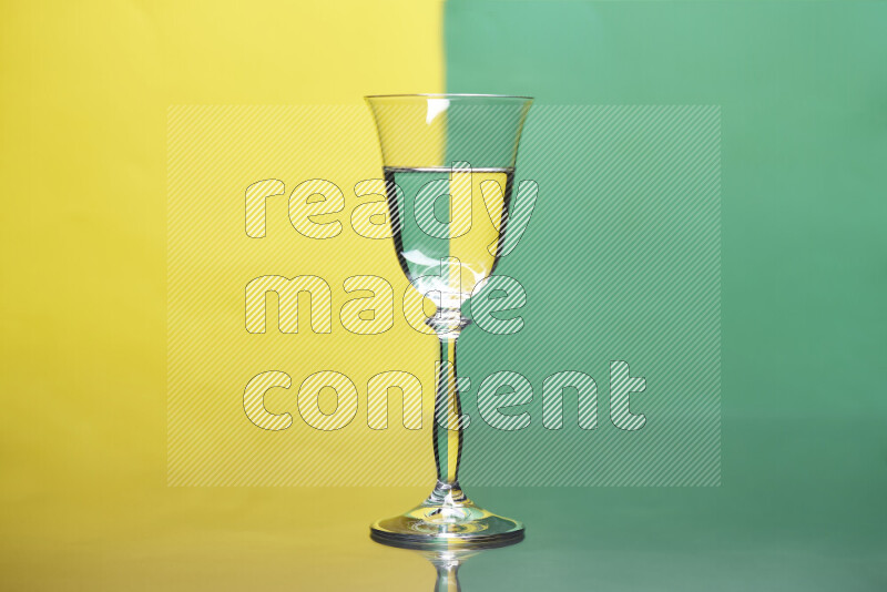 The image features a clear glassware filled with water, set against yellow and green background